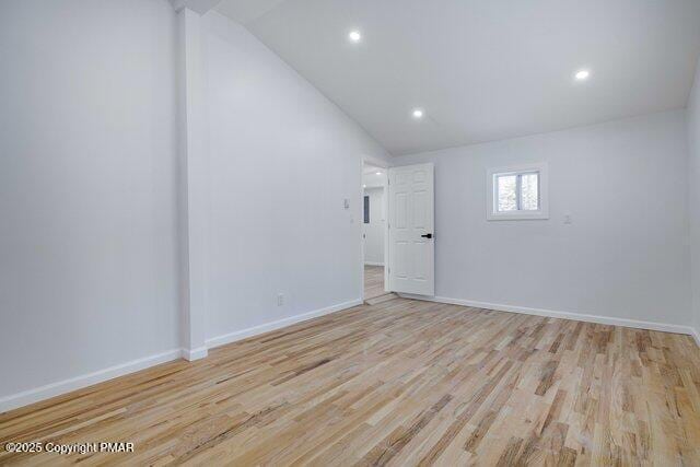 empty room with recessed lighting, baseboards, lofted ceiling, and light wood-style floors