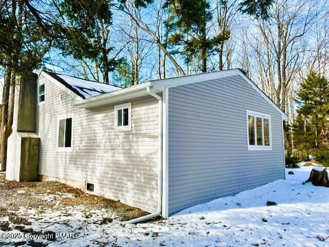 view of snowy exterior with crawl space