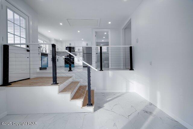 staircase with recessed lighting, marble finish floor, and attic access