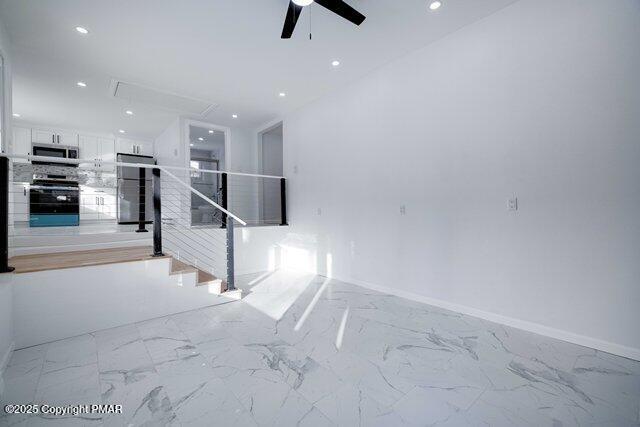 interior space featuring recessed lighting, marble finish floor, attic access, and ceiling fan