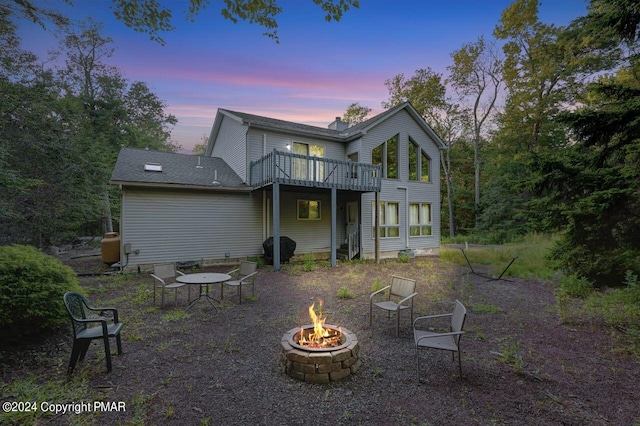 rear view of house featuring a fire pit and a deck