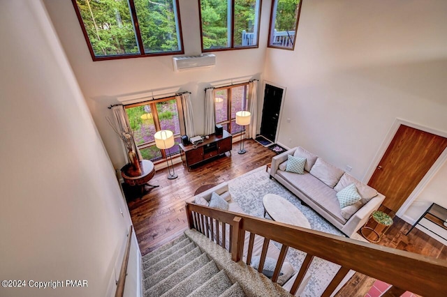 living room featuring hardwood / wood-style floors, stairway, a high ceiling, and a wealth of natural light