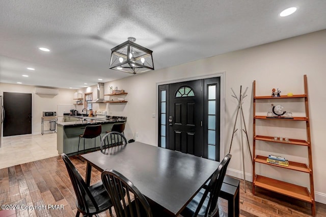 dining area featuring recessed lighting, baseboards, a textured ceiling, and hardwood / wood-style floors