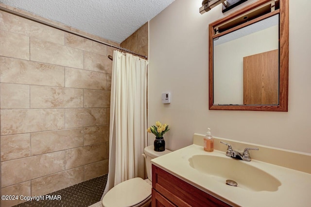 bathroom featuring tiled shower, toilet, a textured ceiling, and vanity