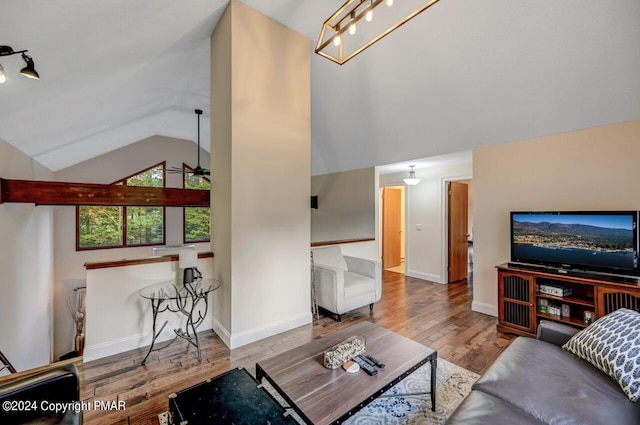 living room featuring baseboards, lofted ceiling, hardwood / wood-style floors, and a ceiling fan