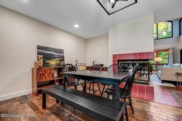 dining room featuring recessed lighting, baseboards, hardwood / wood-style floors, and a fireplace