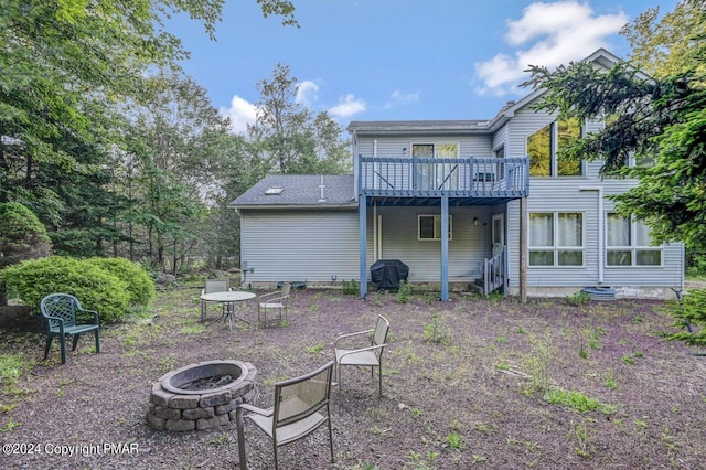 rear view of house featuring a fire pit and a deck