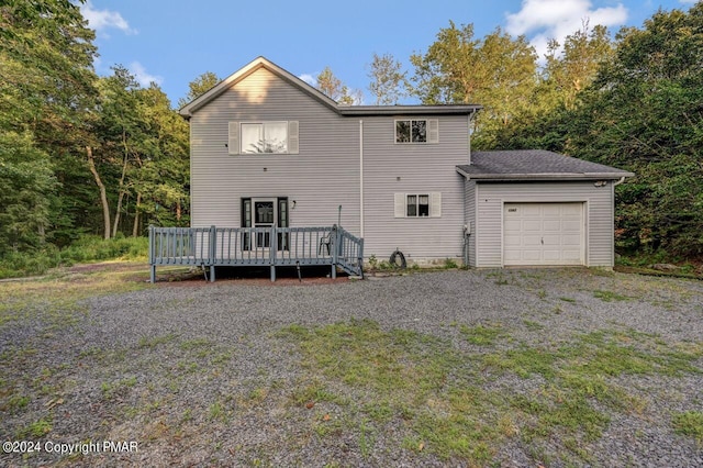 back of house featuring a deck and a garage