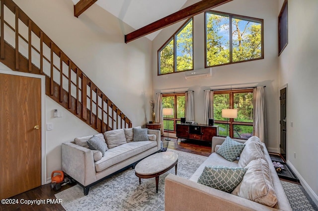 living area featuring beam ceiling, wood finished floors, a wall unit AC, baseboards, and stairs