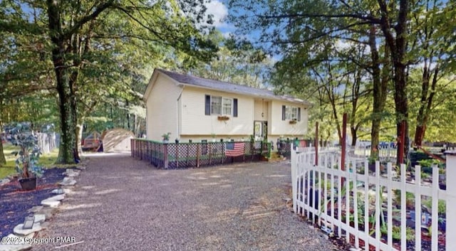 view of front of house with gravel driveway and fence