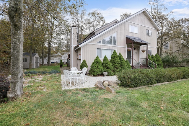 view of front of house with a front yard, a chimney, an outdoor structure, a patio area, and a storage unit