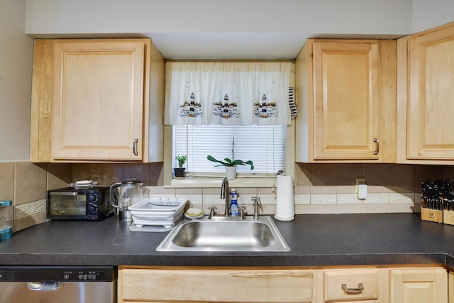 kitchen with dark countertops, light brown cabinets, dishwasher, decorative backsplash, and a sink