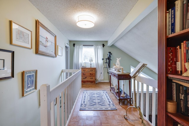 hallway with a textured ceiling and vaulted ceiling with beams