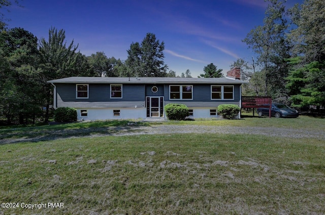 split foyer home with a chimney and a front lawn