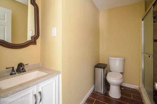 bathroom featuring vanity, an enclosed shower, and toilet