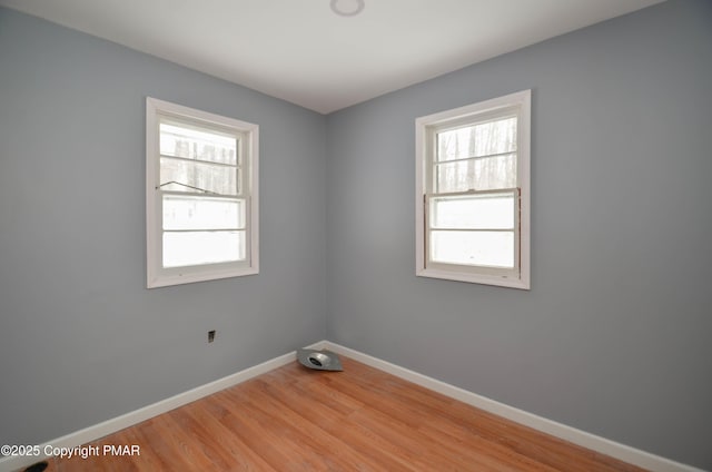 empty room featuring a healthy amount of sunlight and hardwood / wood-style floors