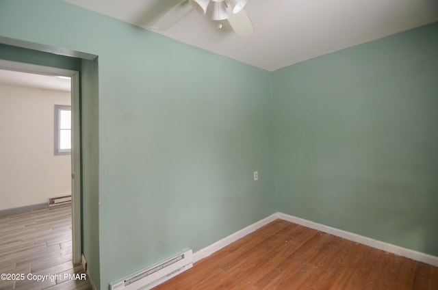 empty room featuring baseboard heating, ceiling fan, and light wood-type flooring