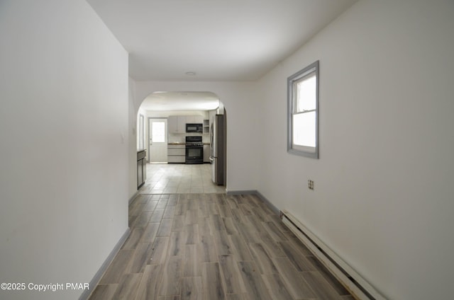 hallway with baseboard heating and wood-type flooring