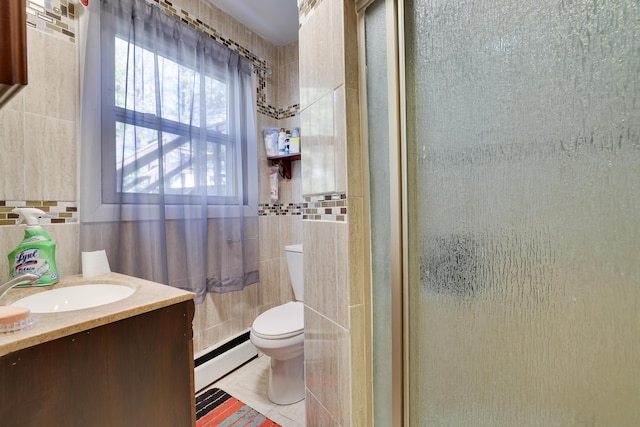 bathroom featuring a baseboard heating unit, tile walls, toilet, and tile patterned flooring