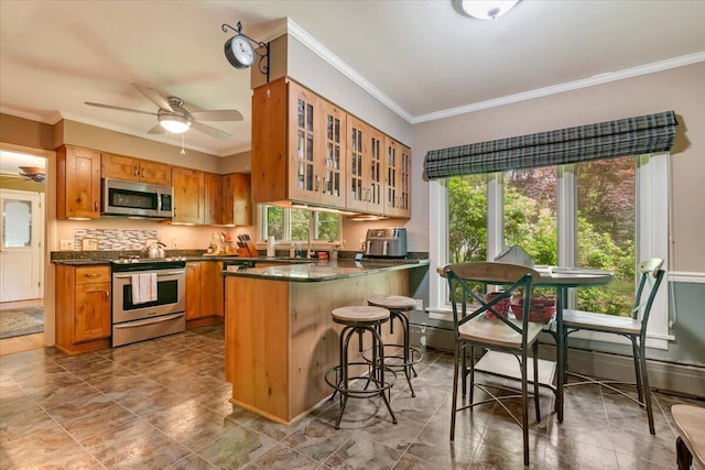 742 White Oak Rd, Cresco, PA 18326 - kitchen with stainless steel appliances, dark countertops, ornamental molding, glass insert cabinets, and a breakfast bar