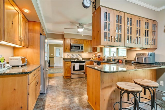 742 White Oak Rd, Cresco, PA 18326 - kitchen featuring appliances with stainless steel finishes, a peninsula, dark stone counters, a breakfast bar area, and crown molding