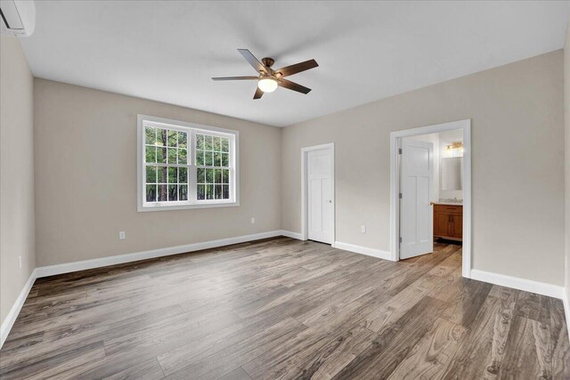 111 Parker Mews, Albrightsville, PA 18210 - unfurnished bedroom featuring wood finished floors, a wall mounted air conditioner, baseboards, and ensuite bathroom