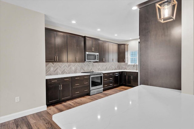 111 Parker Mews, Albrightsville, PA 18210 - kitchen with stainless steel appliances, wood finished floors, decorative backsplash, dark brown cabinetry, and baseboards