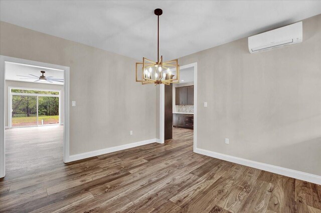 111 Parker Mews, Albrightsville, PA 18210 - spare room featuring a wall unit AC, baseboards, wood finished floors, and a chandelier