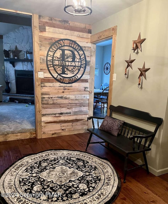 hallway with baseboards, wood finished floors, and a notable chandelier