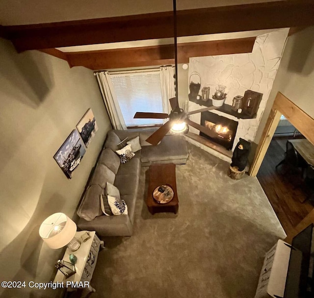 carpeted living room featuring a fireplace and beam ceiling