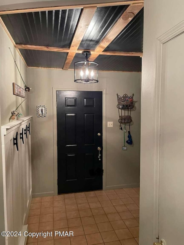 foyer entrance with beam ceiling, baseboards, and light tile patterned floors