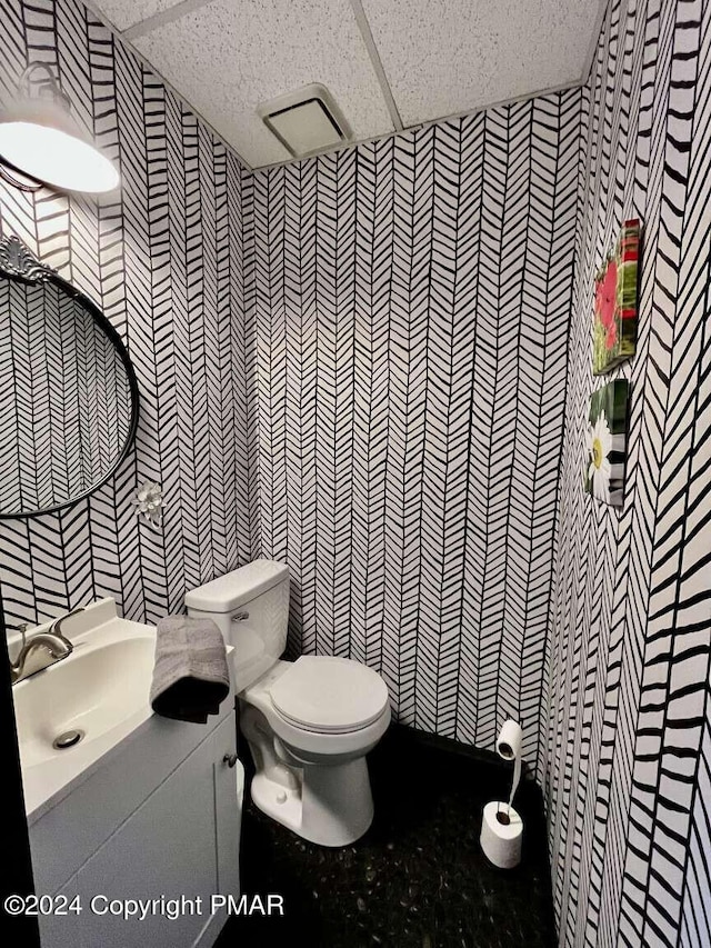 bathroom featuring toilet, tile walls, a paneled ceiling, and vanity