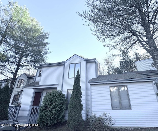 view of side of property with roof with shingles