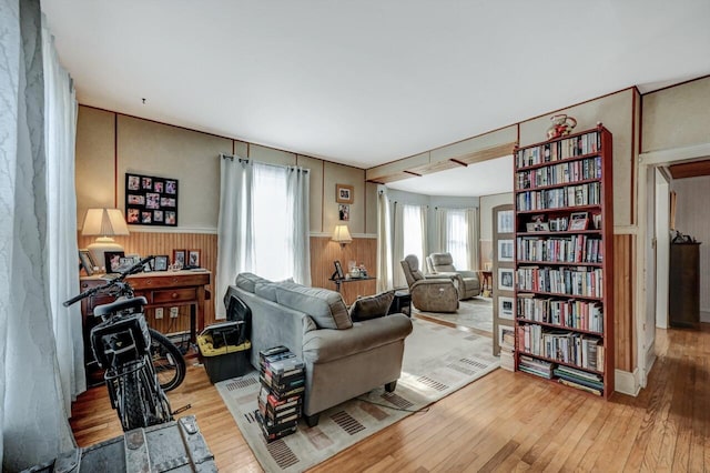 living area with wood finished floors, wood walls, and wainscoting