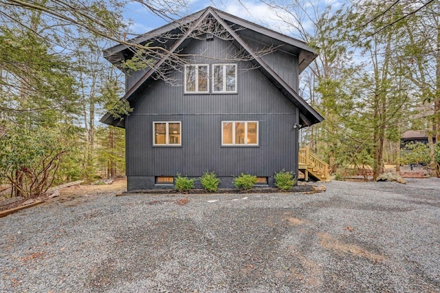 view of side of home with gravel driveway