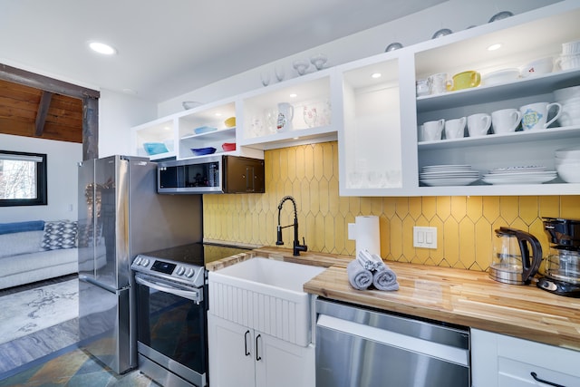 kitchen featuring open shelves, stainless steel appliances, backsplash, and wood counters