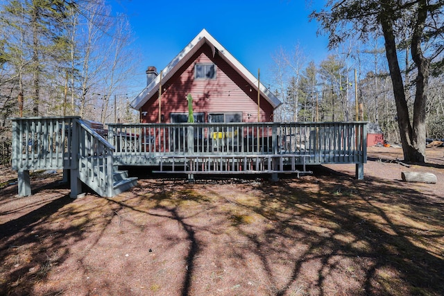 back of house featuring a chimney and a wooden deck