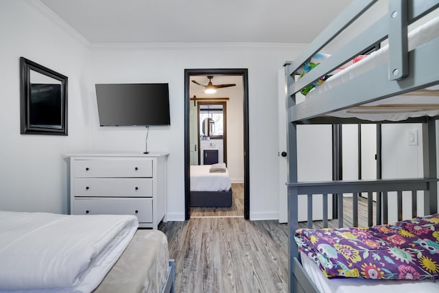 bedroom featuring wood finished floors, baseboards, and ornamental molding