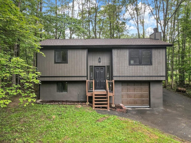 148 Acorn Ln, Kunkletown, PA 18058 - split foyer home featuring an attached garage, a chimney, driveway, and roof with shingles