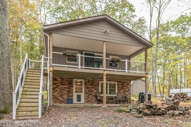 back of property featuring stairway and brick siding