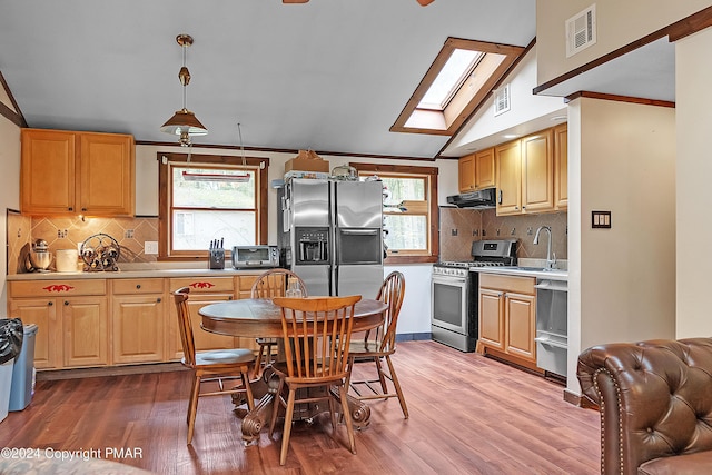 kitchen with stainless steel appliances, plenty of natural light, light wood finished floors, and extractor fan