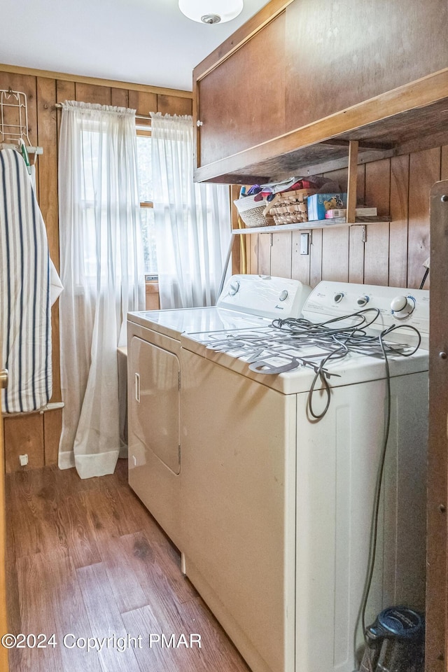 washroom with laundry area, wood finished floors, and washing machine and clothes dryer