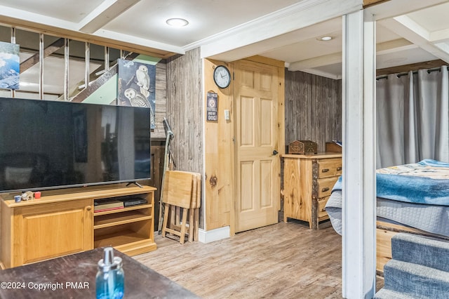 interior space with stairs, beamed ceiling, wooden walls, and wood finished floors