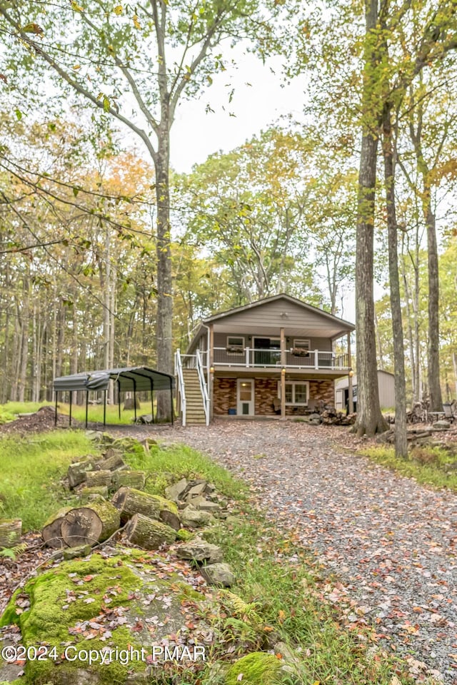 view of front facade with a deck, a carport, and stairs