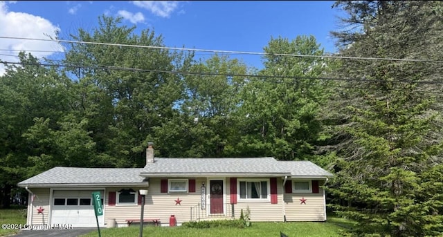 single story home featuring a front yard, a chimney, and an attached garage