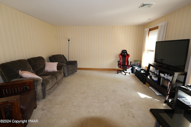 carpeted living room with visible vents, baseboards, and wallpapered walls