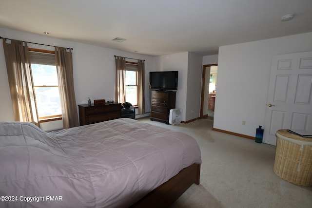 bedroom featuring baseboards, visible vents, and light colored carpet