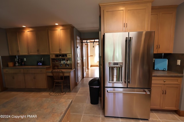 kitchen featuring light tile patterned floors, decorative backsplash, stainless steel fridge with ice dispenser, built in desk, and recessed lighting