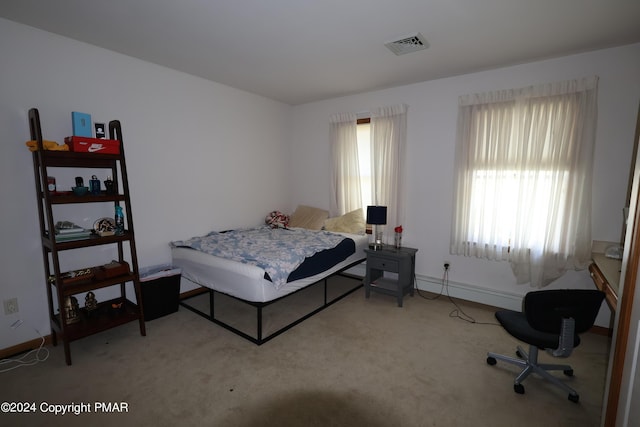 bedroom featuring carpet floors, a baseboard radiator, visible vents, and baseboards