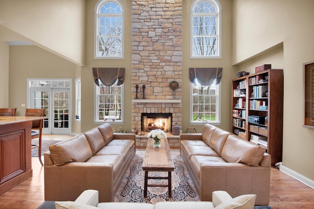 117 Morning Side Ter, East Stroudsburg, PA 18302 - living room with light wood finished floors, a stone fireplace, a high ceiling, and a healthy amount of sunlight